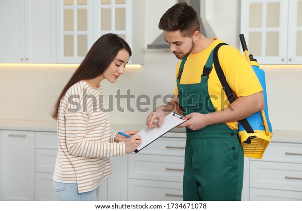 Woman\
signing documents at home. Pest control\
service