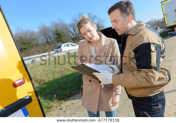 woman\
signing insurance paperwork after a car\
breakdown