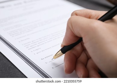 Woman Signing Last Will And Testament At Grey Table, Closeup