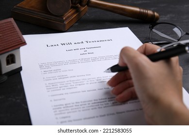 Woman Signing Last Will And Testament At Black Table, Closeup