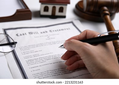 Woman Signing Last Will And Testament At White Table, Closeup