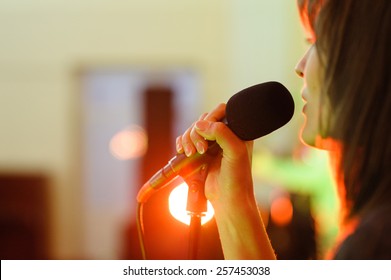A woman signing live concert focus on microphone