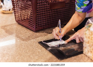 Woman signing slip payment credit card in local shop. - Powered by Shutterstock