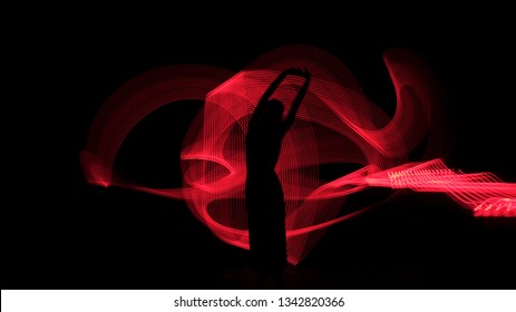 Woman Silhouette Against Red Backlight. Light Painting Photography. Long Exposure.