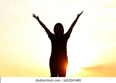 woman silhouette arms up to the sunset feeling happy and freedom. - Shutterstock ID 1653241489
