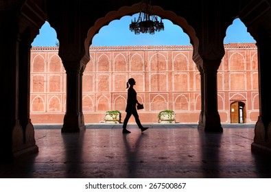 Woman silhouette with guidebook walking in the City Palace museum, Jaipur, Rajasthan, India