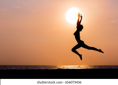 Woman Silhouette Jumping On Sunset Sea Background, Back Lit
