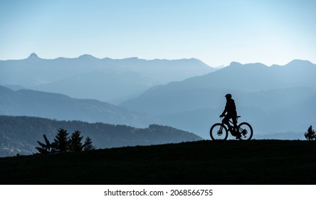 Woman as silhouette riding her electric mountain bike in the Allgaeu alps near Oberstaufen with awesome view into the Bregenz Wald Mountains, Vorarlberg , Austria - Shutterstock ID 2068566755