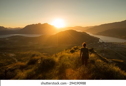 Woman silhouette at sunset on the mountain. New Zealand - Powered by Shutterstock