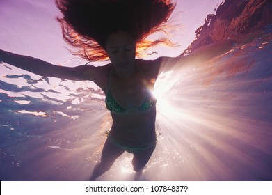 Woman silhouette underwater in swimming pool with back light. - Powered by Shutterstock