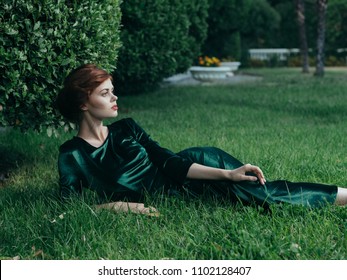 Woman In A Silk Dress Lies On A Green Grass