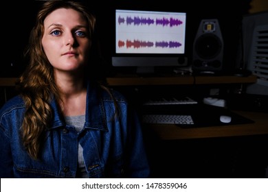 Woman Singer Sitting In A Recording Studio. Vocalist In Place Of The Sound Engineer. Portrait Of A Girl On The Recording Of A Song In The Studio.