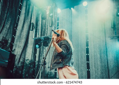 Woman Singing With A Microphone, Colorful Light On Stage