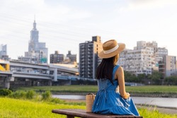 Woman Sit Beside The River Park In Taipei City In The Evening