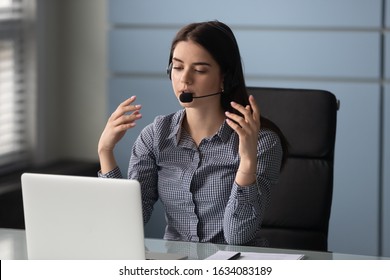 Woman sit at desk in headset helps provide technical support solve issues working at customer service center, telemarketer talk to client telling about goods and prices, or e-learning process concept
