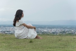 Woman Sit Facing Side On Grass At Top Mountian Look At Sky  Nature View. Feel Relax.
