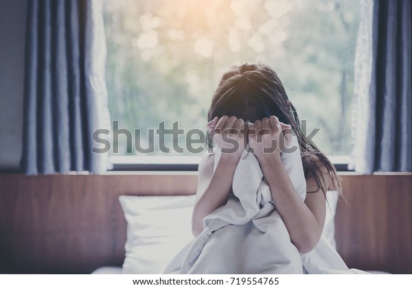 woman sit on a bed in a bedroom -\
concept photo of Sexual assault.,Woman violence\
concept.