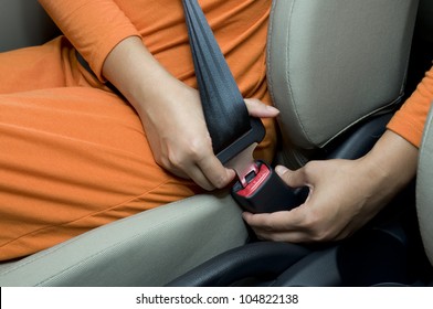 Woman sit on car seat and fasten safety belt