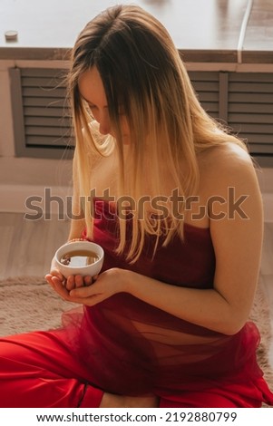 Woman sit on the floor and drink tea from herbs and flowers. Tea ceremony during relaxation harmony