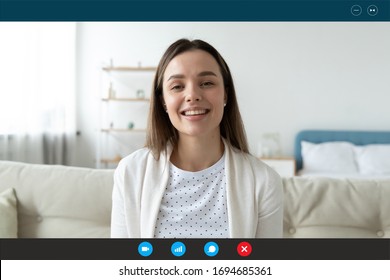 Woman sit on sofa in living room look at cam talk by videocall with friend relatives, head shot. Pass job interview answering questions. Distant chat with verified psychiatrist or psychologist concept