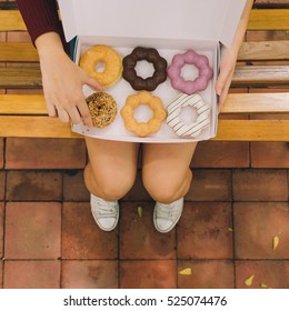 Woman Sit In The Park And Open Donut Box