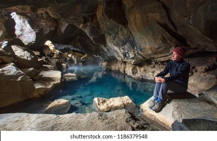 A Woman Sits By A Geothermal Pool In Grjótagjá Cave, Iceland (aka The 