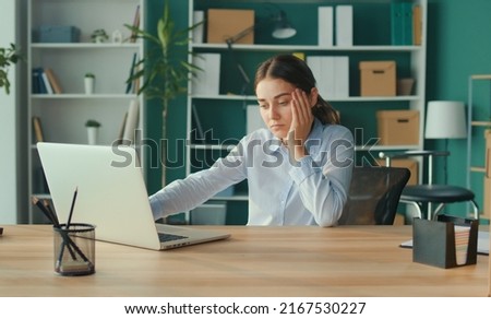 Woman Sits by Table and Do Monotonously Work on Laptop. Improper seating in a Chair. Suffering Officeworker Feeling Sick Because of all the Work,Stress,Backache. Office Syndrome.