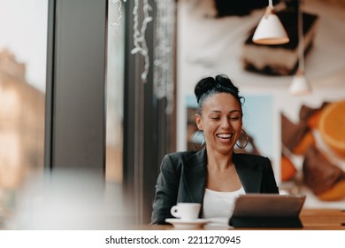 A Woman Sits In A Cafe With Her Arms Raised And Celebrating A Job Well Done.Business Concept