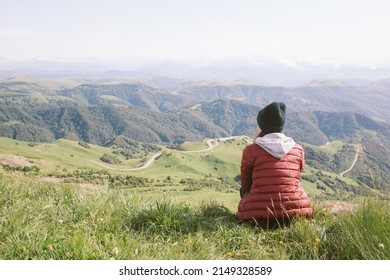 woman is sitting against background of mountains . travel, hiking, journey, outdoor recreation. - Shutterstock ID 2149328589
