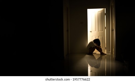 Woman Sitting Alone At The Door In The Dark In A Sad Mood