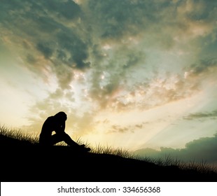 Woman Sitting Alone And Sad Depressed With Meadow, Silhouette Sunset.