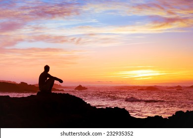 woman sitting alone at sunset near the sea, relaxing and thinking about the meaning of life