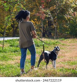 Woman sitting with American Staffordshire terrier on the meadow. - Powered by Shutterstock