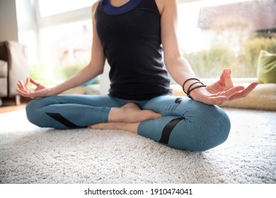 A woman is sitting in asana crossed legs, hands in mudra.