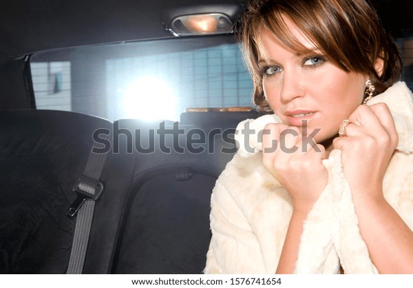A woman sitting in the\
back of a car
