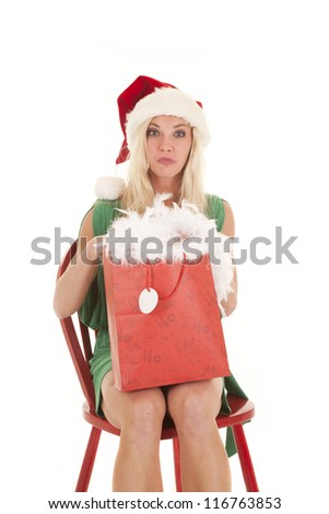 A woman is sitting with a bag she is dressed in a santa hat
