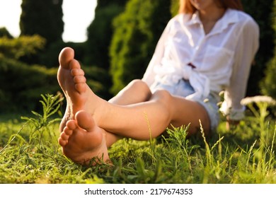 Woman sitting barefoot on green grass outdoors, closeup - Shutterstock ID 2179674353