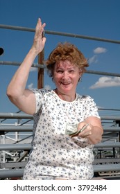 A Woman Sitting In The Bleachers Calling The Hot Dog Vendor