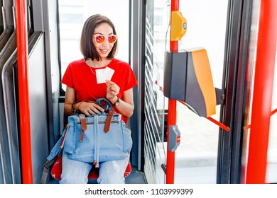 Woman sitting in bus and her showing tickets - Powered by Shutterstock