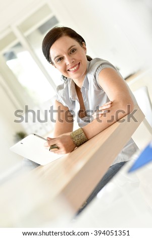 Woman sitting in businessroom with digital tablet