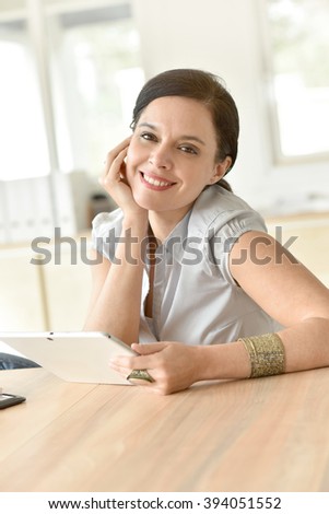 Woman sitting in businessroom with digital tablet