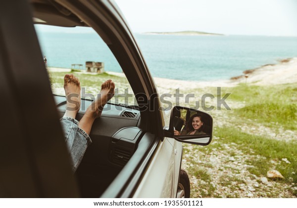 woman sitting in car looking at sea.\
reflection in mirror. copy space. vacation\
concept
