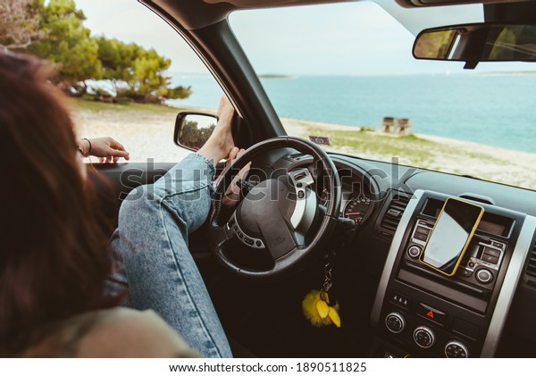 woman\
sitting in car relaxed and looking at sea\
beach