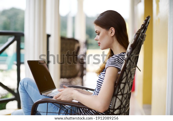 woman\
sitting in a chair with laptop outdoors\
freelance
