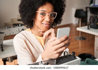 Woman Sitting Checking Her Smartphone During The Break After Re Sewing Old Clothes