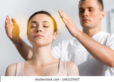 Woman Sitting With Closed Eyes While Healer Cleaning Her Aura