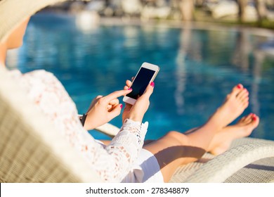 Woman sitting in deck chair and using mobile phone - Powered by Shutterstock