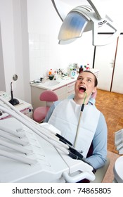 Woman Sitting In Dentist Chair With Suction Tube