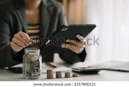 Woman sitting at desk managing expenses, calculating expenses, paying bills using laptop online, making household financial analysis, closer focus on the white piggy bank. 