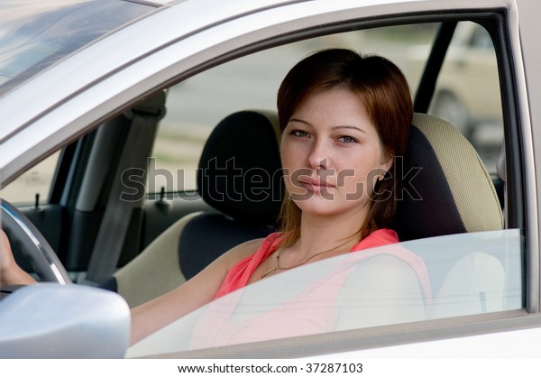 A woman\
sitting in the driver\'s seat of a\
car